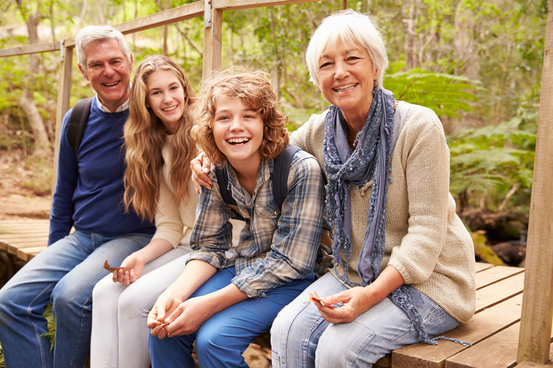 Grandparents sitting with grandchildren on a bridge - Do Grandchildren Lose Interest in Their Grandchildren - TheGrandkidConnection.com