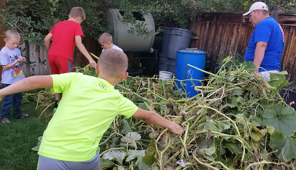 Grandkids working in garden with their grandfather - Gardening with kids lessons - The Grandkid Connection