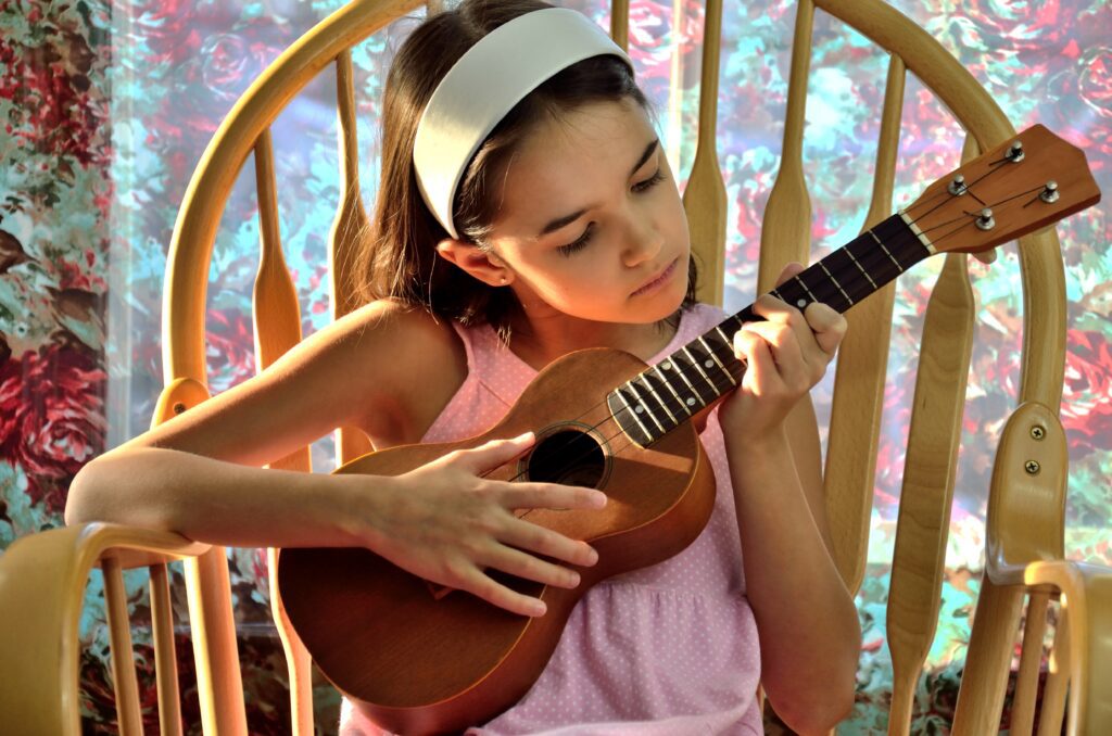 Young girl playing the ukelele - The Grandkid Connection