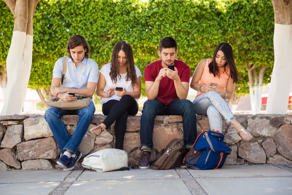A group of teenagers on devices not talking to anyone else - The Grandkid Connection