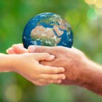 Grandparent and grandchild holding a model of the earth - Earth day activities - The Grandkid Connection