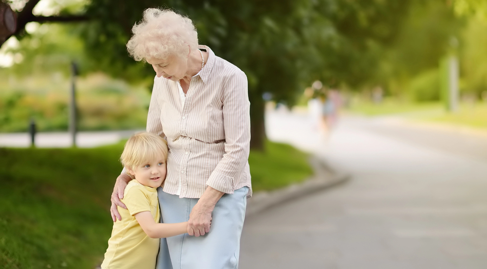A grandmother hugging her grandchild while standing on the side of the road - Back to School - The Grandkid Connection
