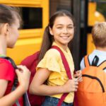 Kids getting on a school bus - Back to school - The Grandkid Connection